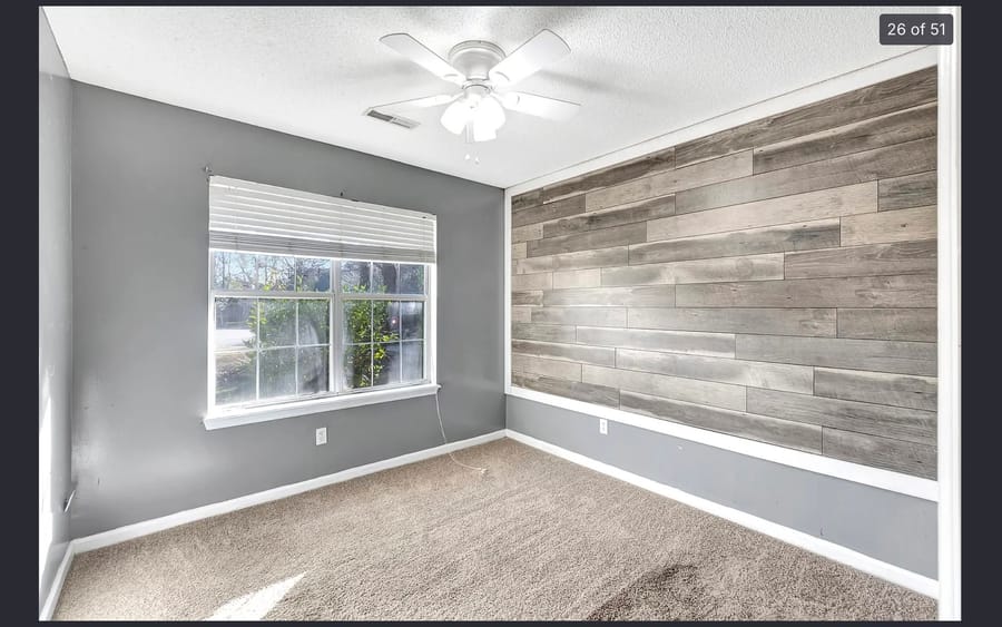 Entry with a wrought iron front door and a backlit fluted wood accent wall