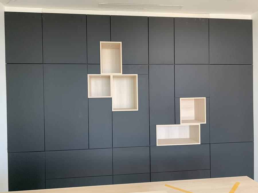 Charcoal cabinet wall with staggered light wood display cubbies