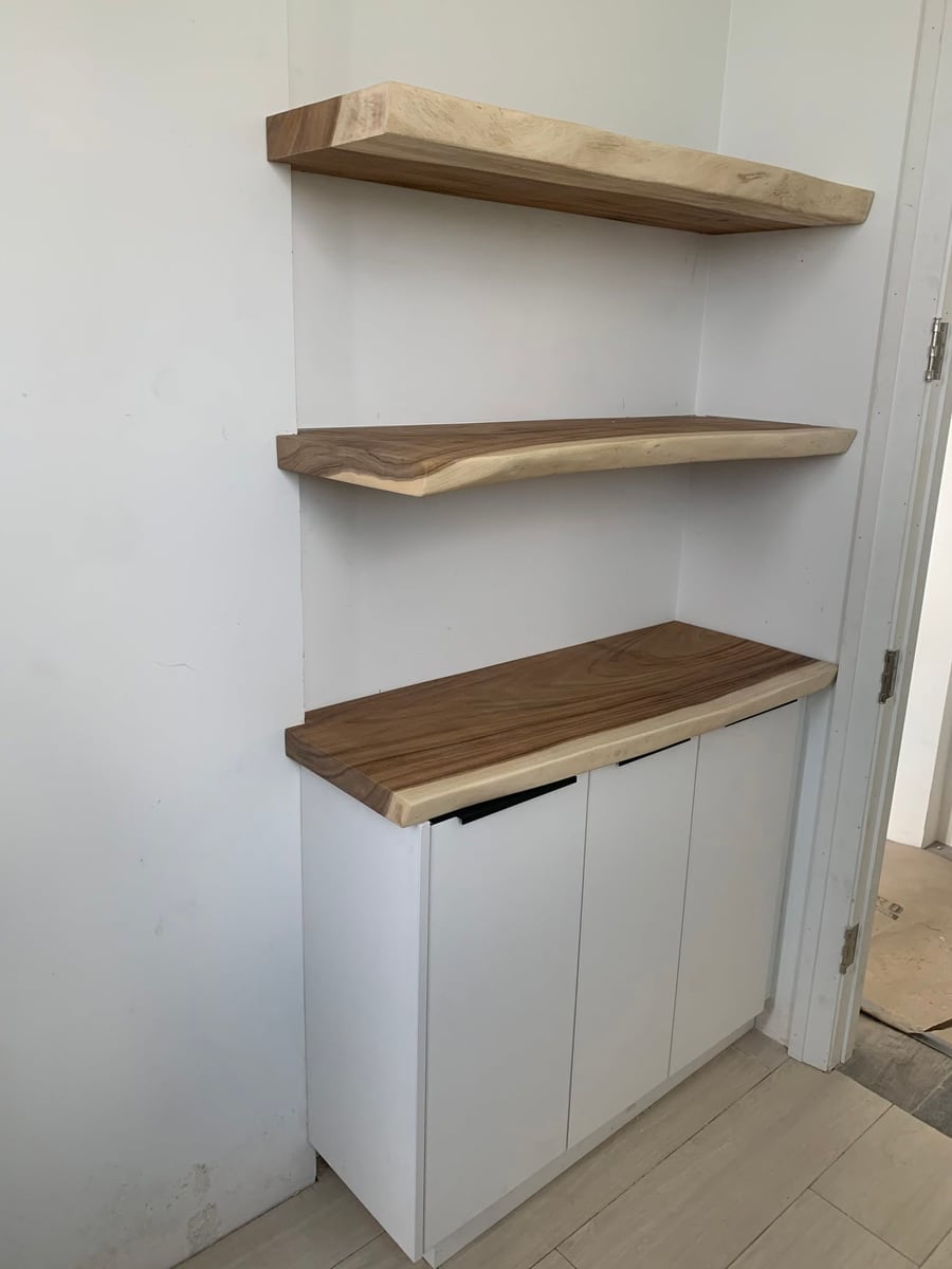 Floating timber shelves above a white cabinet