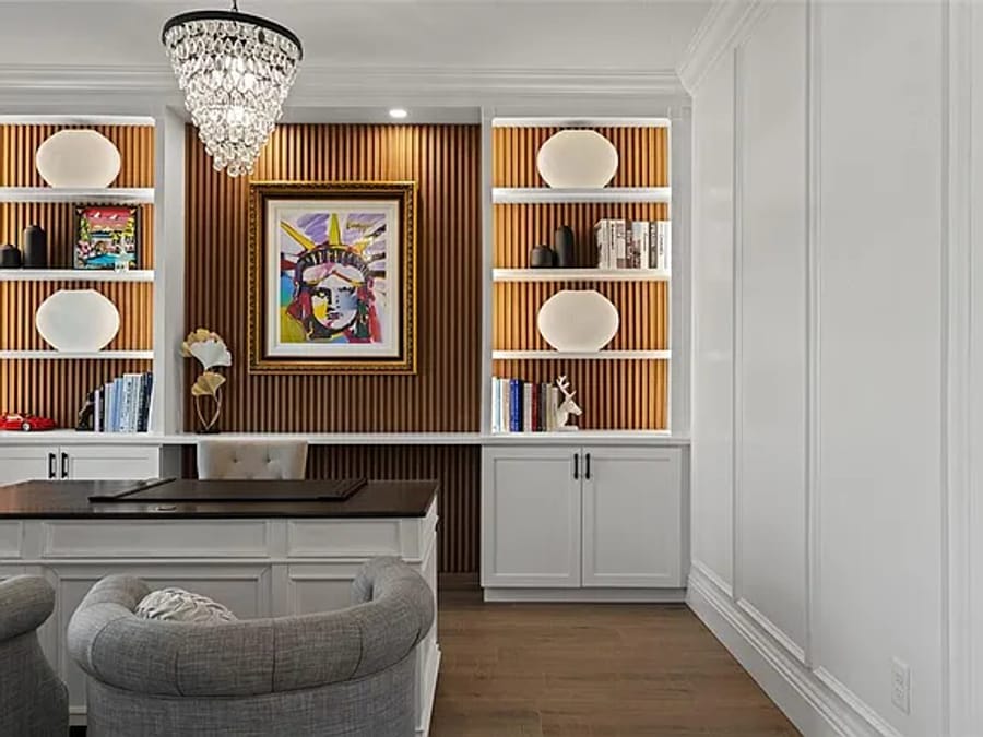 Built-in bookcases flanking a fluted wood feature wall in a home office