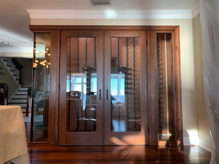 Wine cellar entry framed in timber and glass doors