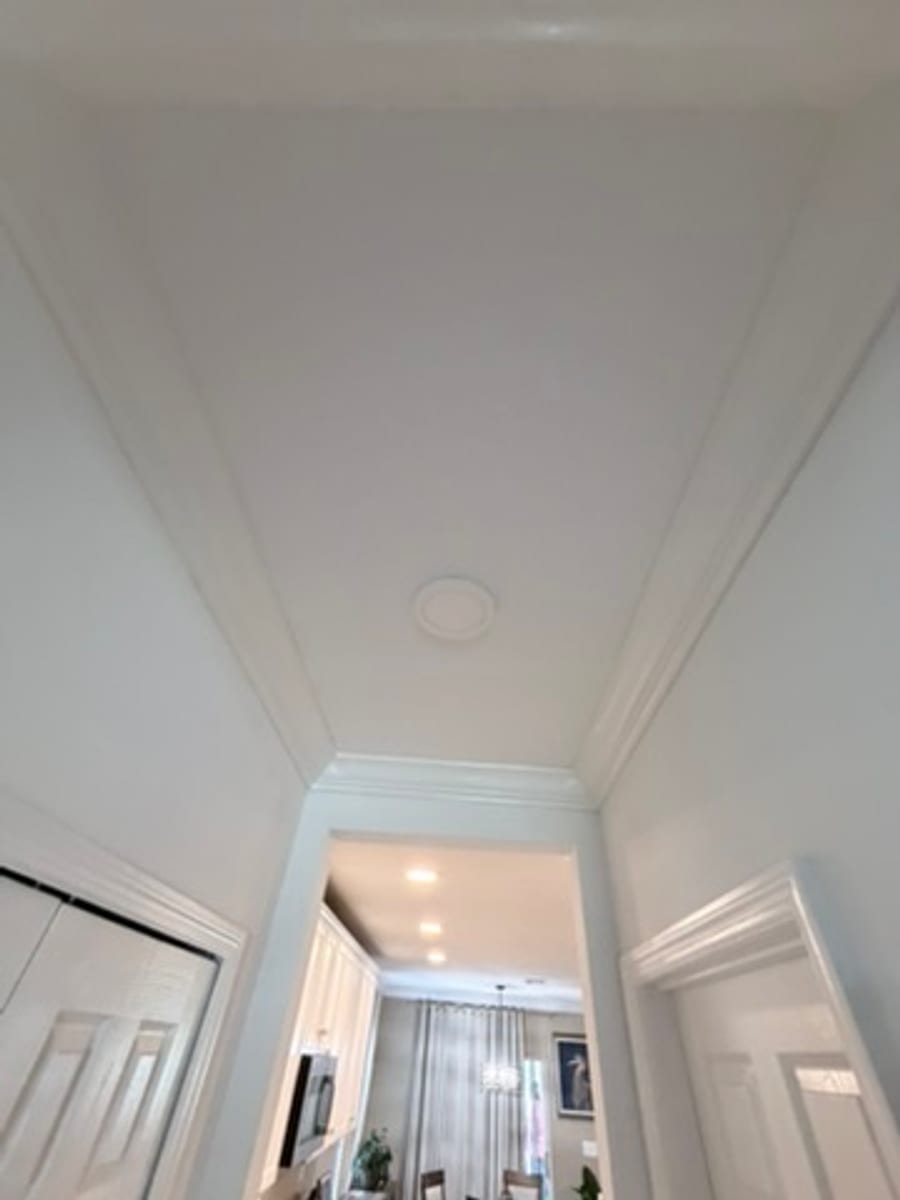 Crown molding along a hallway ceiling opening into the kitchen
