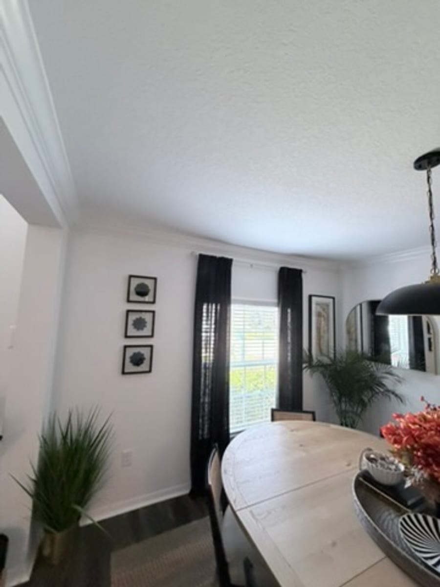 Crown molding in a dining room corner near a curtained window