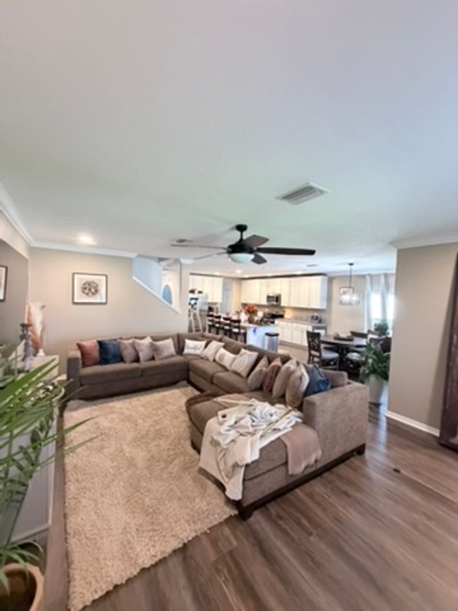 Open concept living room with crown molding along the ceiling perimeter