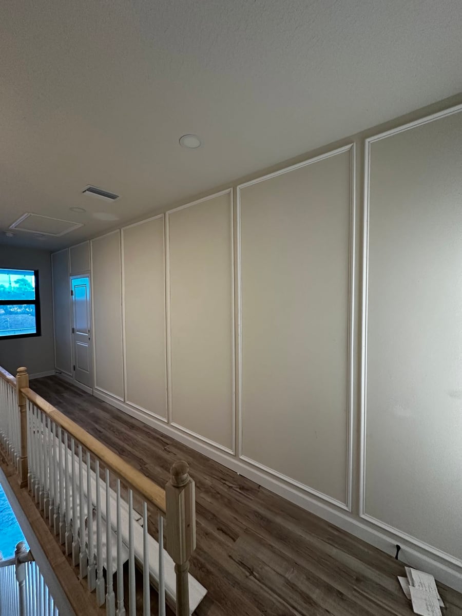 Panelled hallway with applied moulding above a timber handrail