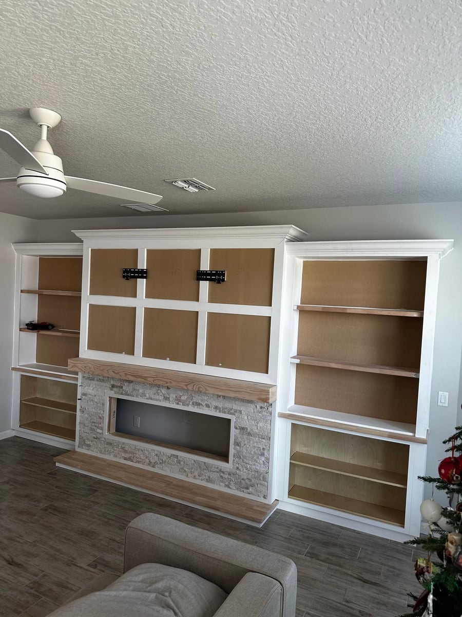 White built-in with a stone fireplace and open shelving
