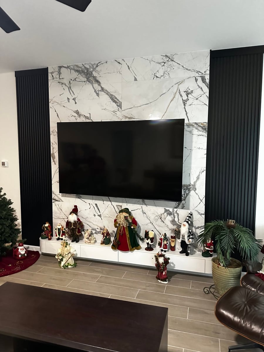 Marble TV wall flanked by black slat panelling